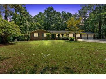 Charming brick home with a spacious front yard and mature trees offering shade and curb appeal at 2144 Kennesaw Due West Nw Rd, Kennesaw, GA 30152
