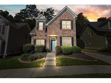 Charming brick home with manicured lawn, black shutters, and a welcoming entrance with landscape lighting at 3606 High Battery Nw Blf, Acworth, GA 30101