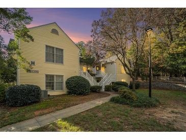 Evening view of a yellow two-story building with stairs and landscaping at 918 Cannongate Sw Xing, Marietta, GA 30064