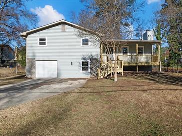 Newly renovated house with gray siding, a detached garage, and a wooden deck at 488 Village Run, Lawrenceville, GA 30046