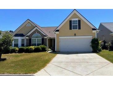 Tan two-story house with a large driveway and manicured lawn at 1060 S Creek Dr, Villa Rica, GA 30180