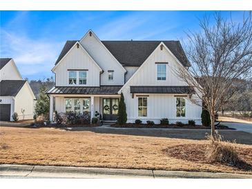 Two story white farmhouse with metal roof, landscaping and large driveway at 4730 Down Setting Rd, Cumming, GA 30028