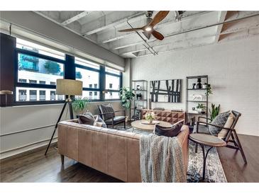 Stylish living room featuring exposed brick, large windows, and modern furnishings creating an inviting space at 878 Peachtree Ne St # 535, Atlanta, GA 30309