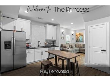 Fully renovated basement kitchen with white cabinets, stainless steel appliances, and a breakfast bar at 1174 Princess Sw Ave, Atlanta, GA 30310