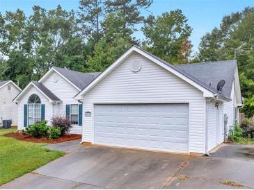 White house with a two-car garage and well-maintained lawn at 4037 Monarch Dr, Mcdonough, GA 30253