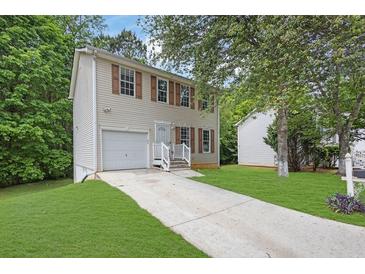 Charming two-story home features a well-maintained front yard and a welcoming entrance with light colored siding at 4127 Conley Pond Ct, Decatur, GA 30034