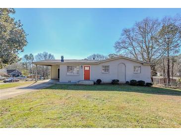 Ranch style home with brick exterior, red door, and carport at 9105 Griffin Sw Ln, Covington, GA 30014