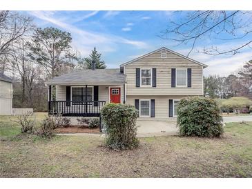 Charming two-story home featuring a cozy front porch and a classic red front door at 3045 Flat Shoals Rd, Atlanta, GA 30349