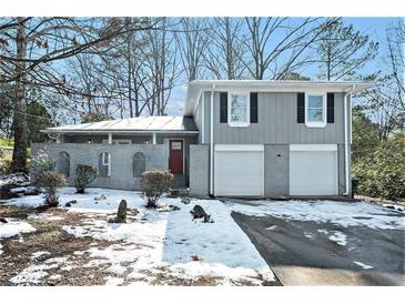 Gray two-story house with a two-car garage and a snow-covered front yard at 4509 Central Dr, Stone Mountain, GA 30083