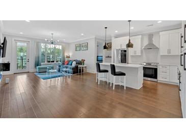 Bright and airy living room featuring hardwood floors, comfortable seating, and a modern ceiling fan at 6890 Peachtree Dunwoody Rd # 303, Atlanta, GA 30328