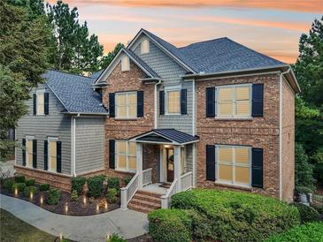 Two-story home with brick and siding exterior, landscaping, and a covered entryway at 3950 Stanford Dr, Cumming, GA 30041