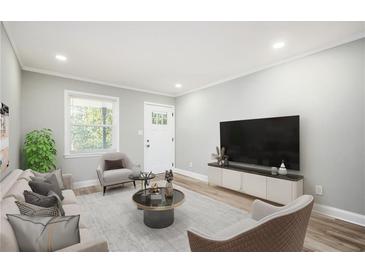 Bright living room with hardwood floors, comfy seating, and large TV at 2198 Star Mist Sw Dr, Atlanta, GA 30311