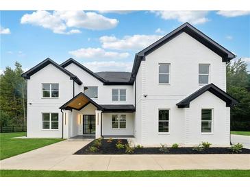 Two-story white brick home with black accents and a modern design at 3165 Hall Rd, Dacula, GA 30019