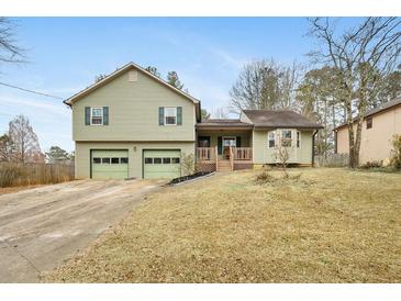 House exterior featuring a two-car garage and a well-manicured lawn at 4036 Evelyn Dr, Powder Springs, GA 30127