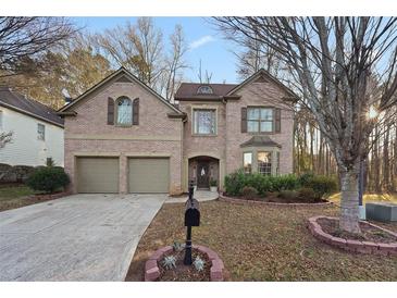 Brick two-story house with a two-car garage and landscaped yard at 437 Cherry Tree Ln, Marietta, GA 30066