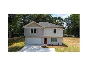 Two-story house with gray and beige siding, a red door, and a two-car garage at 1331 E Atlanta E Rd, Stockbridge, GA 30281