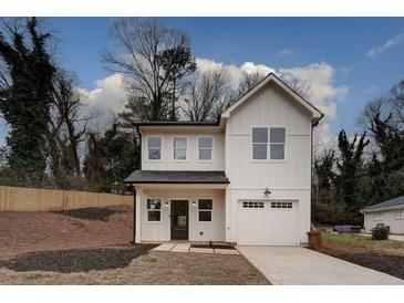 Two-story farmhouse with white siding, black roof, and attached garage at 2127 Nichols Ln, Decatur, GA 30032