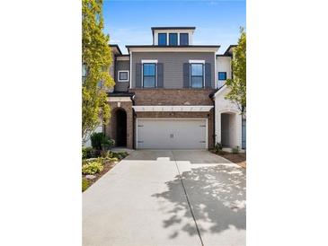 Two-story townhome with gray siding, brick accents, and a two-car garage at 290 Walker Ave, Alpharetta, GA 30076