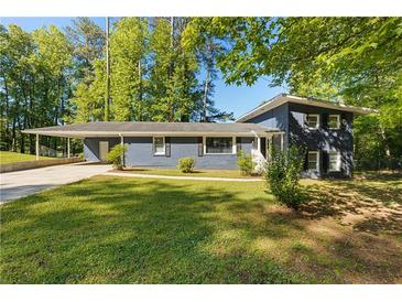 Ranch style home with gray siding, landscaped lawn, and carport at 558 Plainville Dr, Atlanta, GA 30331