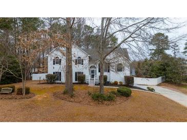 Two story house with white siding, landscaping, and a long driveway at 8255 Stonebrook Dr, Cumming, GA 30040