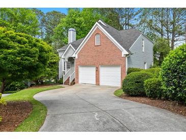 Brick and siding house with a two-car garage and a paved driveway at 135 River Point Ct, Alpharetta, GA 30022