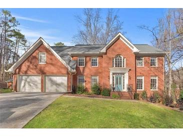 Brick house with a two-car garage and landscaped lawn at 695 Arboreal Ct, Alpharetta, GA 30022