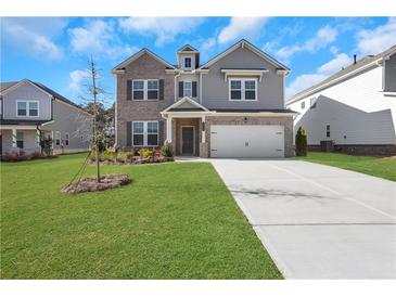 Two-story brick home with gray siding, a two-car garage, and a landscaped lawn at 3069 Shirecrest Lane, Dacula, GA 30019