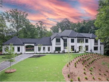 Stunning two-story home with a white brick facade and a landscaped yard at 5271 Lake Forrest Dr, Atlanta, GA 30342