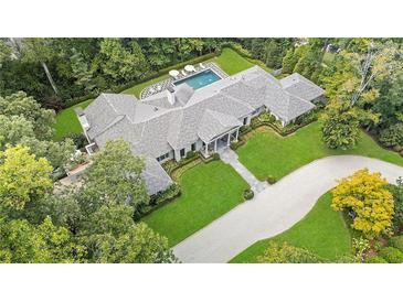 Stunning aerial view of a home surrounded by lush greenery and a luxurious pool with umbrellas at 3612 Castlegate Nw Dr, Atlanta, GA 30327