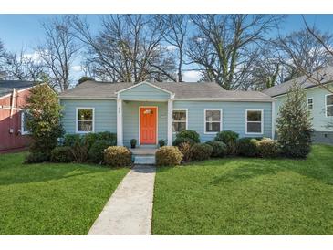 Charming single-story home with light blue siding, an orange front door, and well-maintained landscaping at 67 Holly Nw Rd, Atlanta, GA 30314