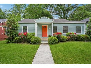 Charming one-story home with a bright orange front door, lush lawn, and manicured landscaping at 67 Holly Nw Rd, Atlanta, GA 30314