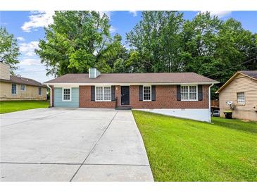 Charming brick home with a spacious front yard and long driveway at 2382 Old Rex Morrow Rd, Ellenwood, GA 30294
