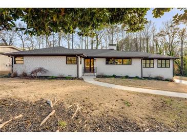 White brick ranch house with dark brown accents, landscaped yard, and a walkway at 705 Glenforest Rd, Atlanta, GA 30328