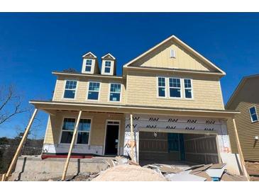 A yellow two-story home under construction with a two-car garage and dormer windows on a sunny day at 628 Gilles Ln, Cumming, GA 30041