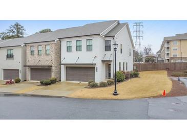 Charming two-story townhouse with a modern garage, manicured landscaping, and a light-brick facade at 1017 Rohner Way, Smyrna, GA 30080