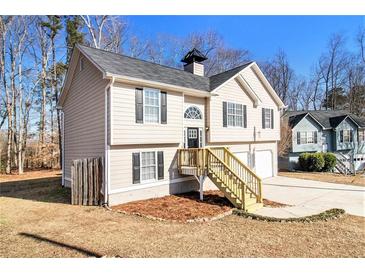 Two-story house with beige siding, attached garage, and wood stairs at 459 Pleasant Way, Temple, GA 30179