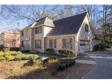 Charming two-story brick home with an attached garage, surrounded by lush landscaping and mature trees at 4116 River Cliff Chase Se, Marietta, GA 30067