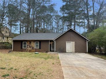 Ranch style home with stone accents and a paved driveway at 5117 Panola Valley Dr, Lithonia, GA 30038