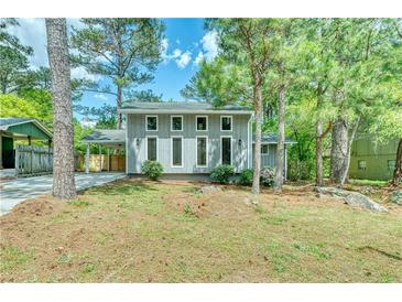 Charming two-story home with a well-maintained front yard and inviting curb appeal surrounded by mature trees at 6360 Ashdale Dr, Atlanta, GA 30349