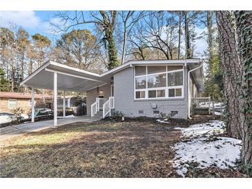 Gray brick ranch house with carport and landscaped yard at 2280 Connally Ct, Atlanta, GA 30344