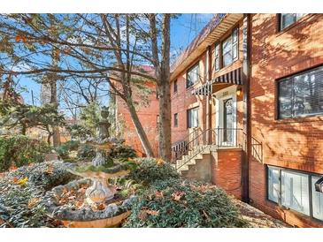 Charming brick condo building with a beautiful fountain and mature landscaping in front at 320 3Rd Ne St # 1, Atlanta, GA 30308