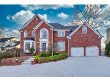 Brick home with two-car garage and landscaped yard at 5615 Forkwood Nw Dr, Acworth, GA 30101