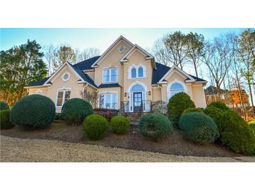 Two-story house with stucco exterior, landscaping, and a welcoming front entrance at 605 Rose Creek Cir, Duluth, GA 30097