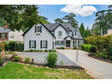 Two-story house with gray siding, black shutters, and a gravel driveway at 1409 Sheridan Ne Rd, Atlanta, GA 30324