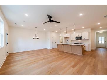 Open living room with hardwood floors and modern ceiling fan at 3309 Cranston Ln, Kennesaw, GA 30144