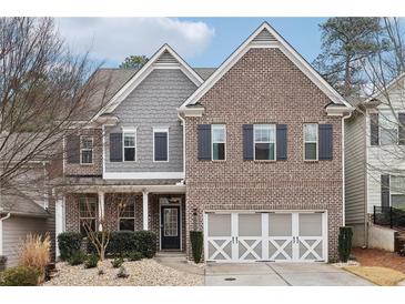 Brick and gray siding two-story home with a three-car garage at 1240 Roswell Manor Cir, Roswell, GA 30076