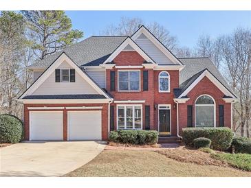 Brick two-story house with a two-car garage and landscaped lawn at 5034 Hickory Hills Dr, Woodstock, GA 30188