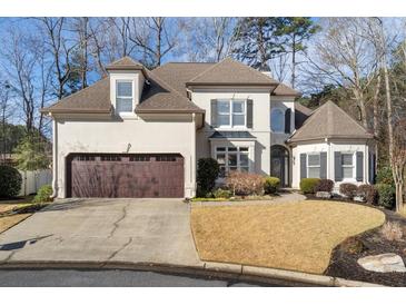 Two-story house with brown double doors and a landscaped yard at 1240 Woodlawn Ne Dr, Marietta, GA 30068