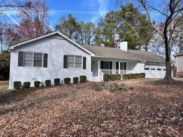 Ranch style home with white brick exterior, attached garage, and mature landscaping at 1737 Ramblewood Way, Snellville, GA 30078