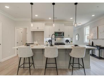 Modern kitchen with white cabinets, quartz countertops, and island at 3305 Cranston Ln, Kennesaw, GA 30144